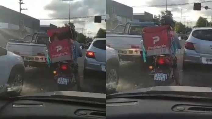 Delivery man carries his son in the delivery box of his motorcycle