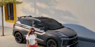 Geely Coolray gris, vista delantera lateral junto a un paso peatonal